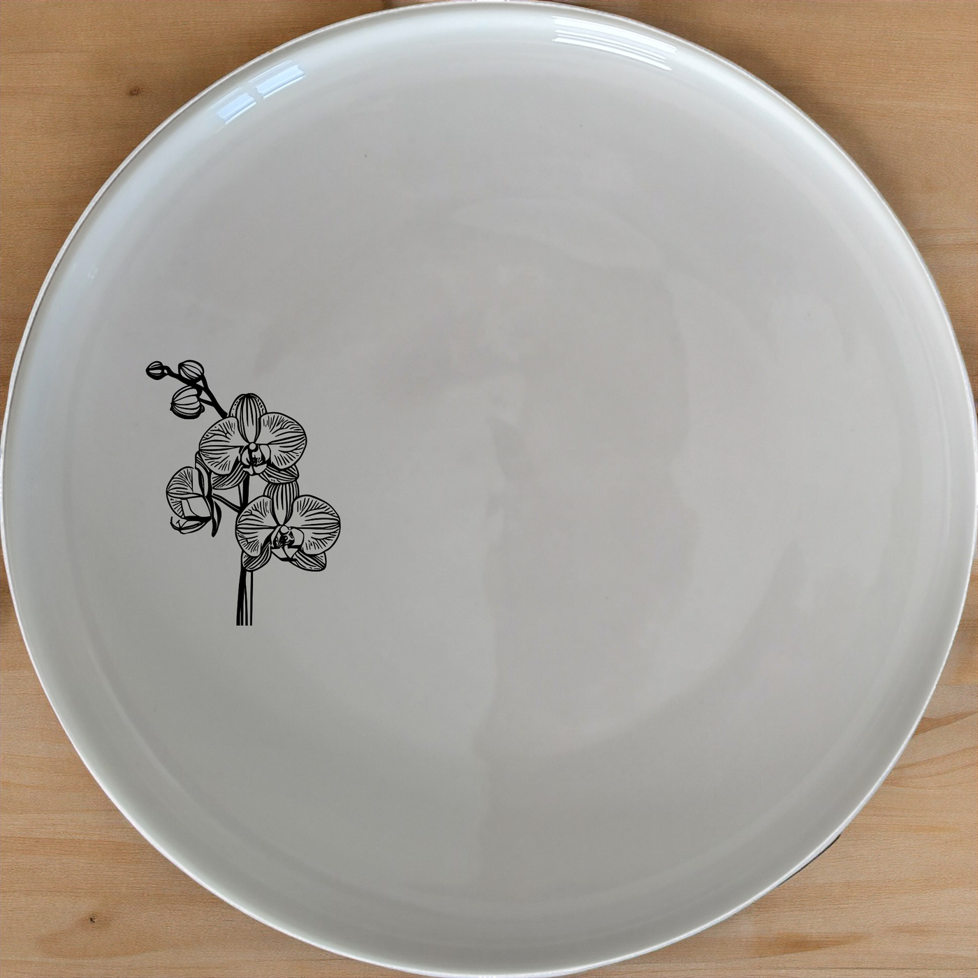 The Orchid Dinner Plate set features a delicate laser-etched orchid design on a pristine white ceramic surface, perfect for elevating any dining experience.