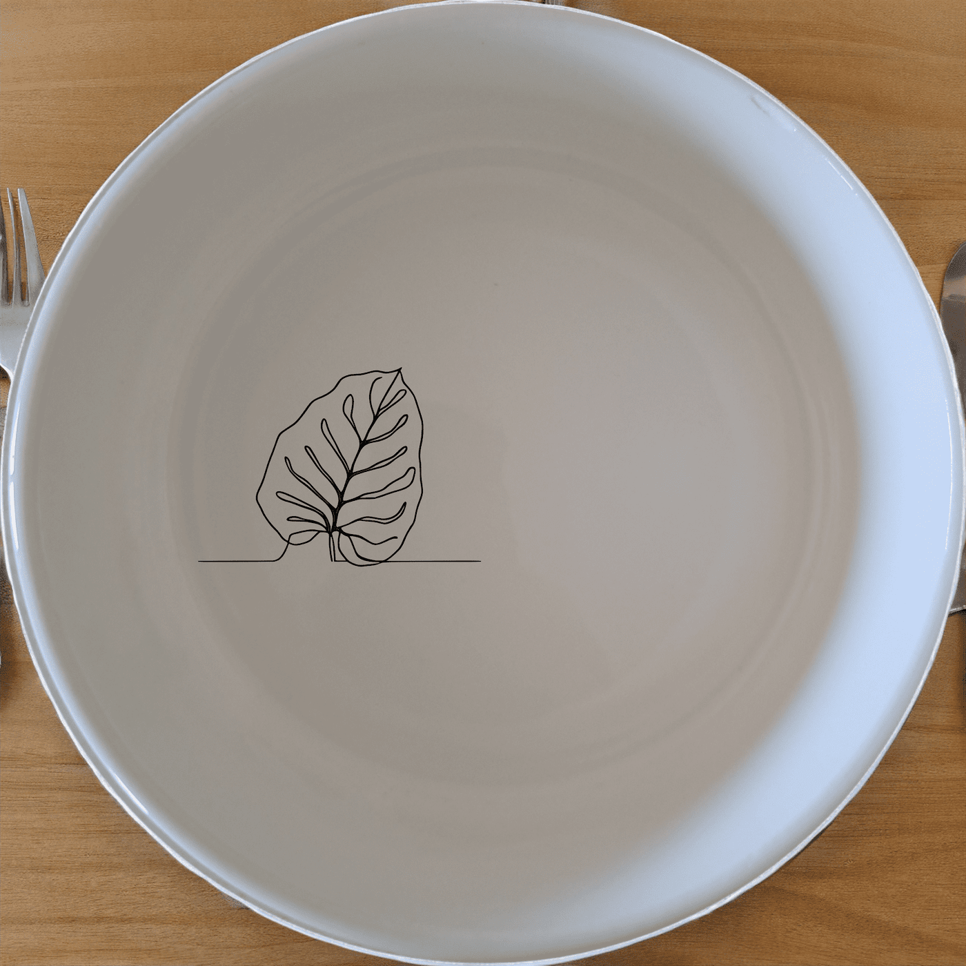 The Calathea Orbifolia Bowl Set of 4 features a minimalist design with a subtle leaf motif, perfect for modern and nature-inspired kitchens.