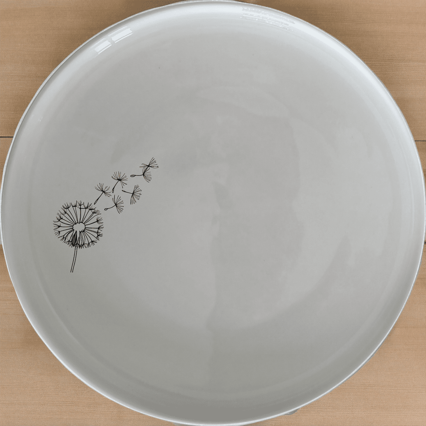 The Dandelion Seeds Side Plate Set of 4 features delicate laser-etched designs on white ceramic plates, perfect for everyday use and special occasions.