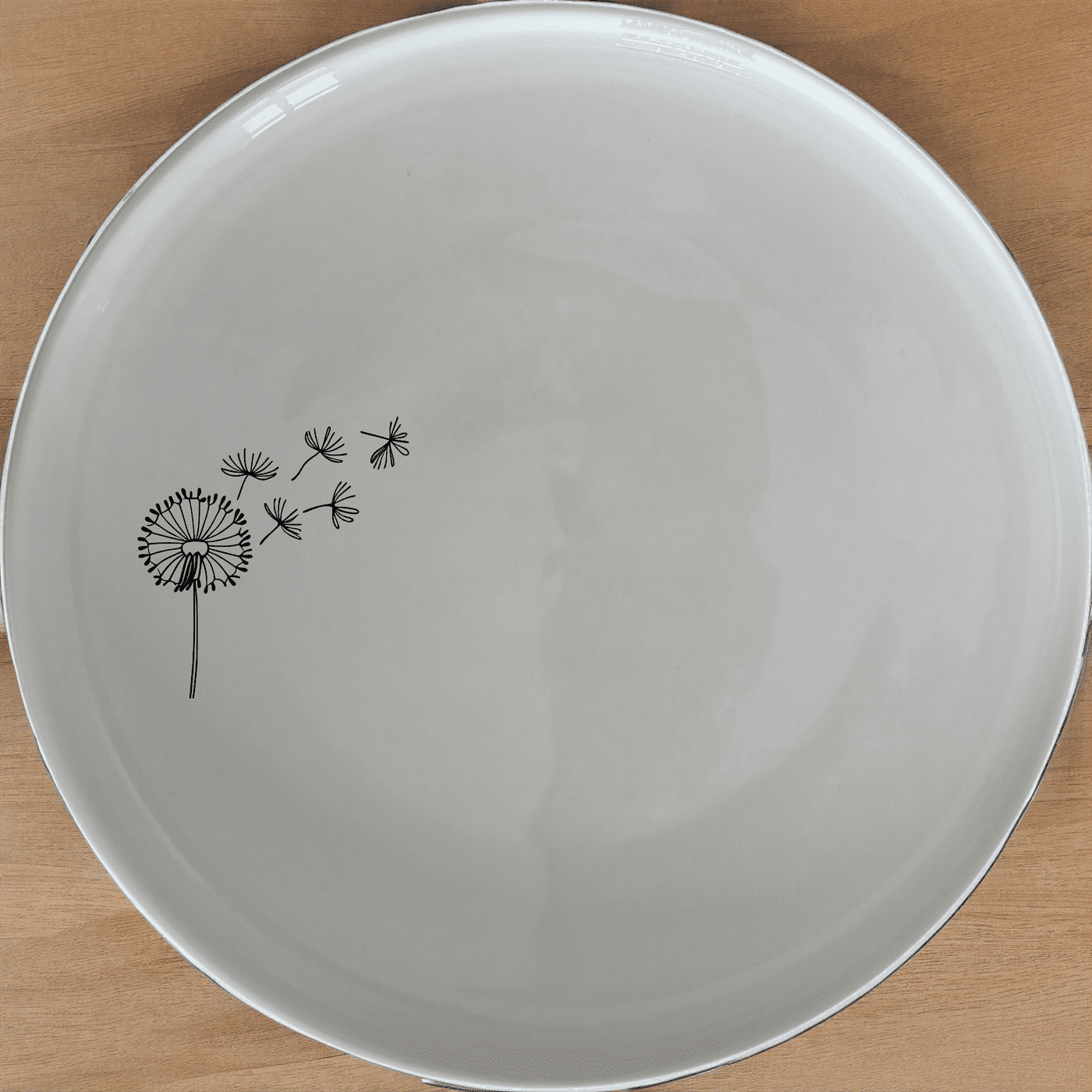 The Dandelion Seeds Side Plate Set of 4 features delicate laser-etched designs on white ceramic plates, perfect for everyday dining or special occasions.