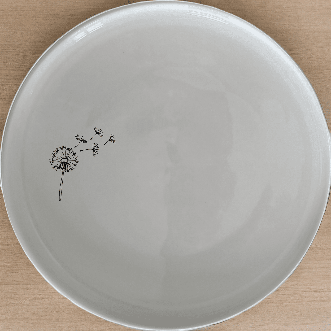 The Dandelion Seeds Dinner Plate Set of 4 features delicate laser-etched designs on white ceramic plates, perfect for everyday elegance and special occasions.