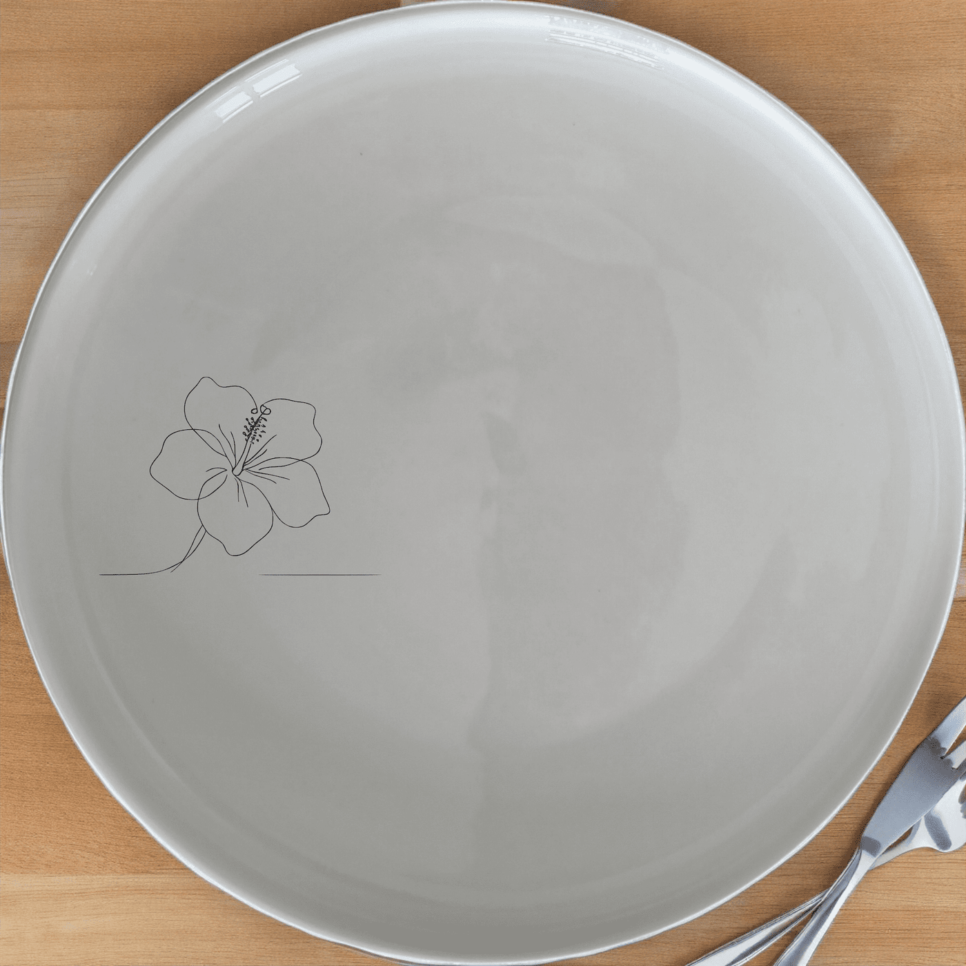 The Delicate Hibiscus Flower Dinner Plate Set of 4 features a minimalist design with an elegant hibiscus flower etched onto a smooth white ceramic surface, perfect for any dining occasion.