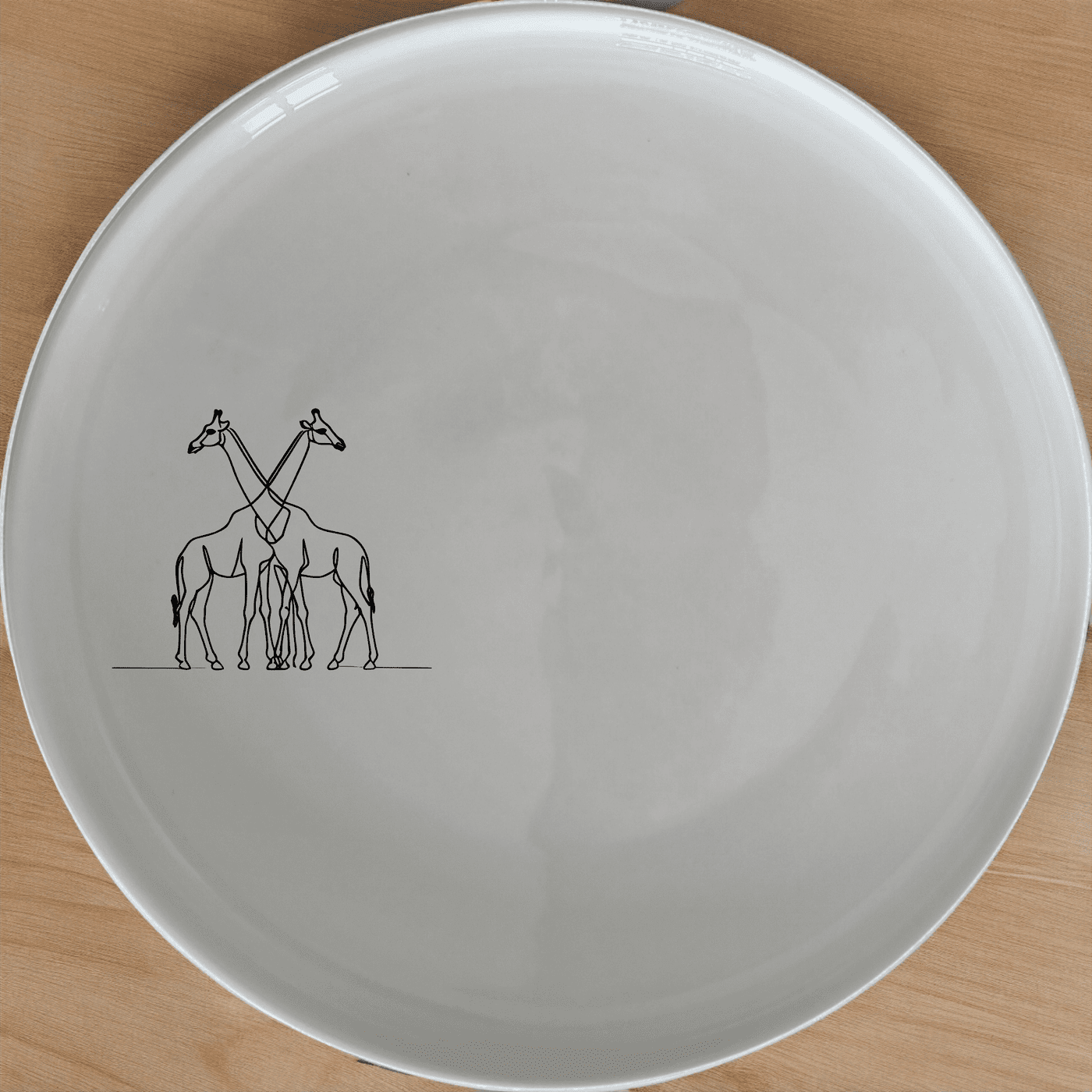 The Elongated Intertwined Girraffes Side Plate Set of 4 adds a unique touch to your dining table with its elegant design and high-quality ceramic construction.