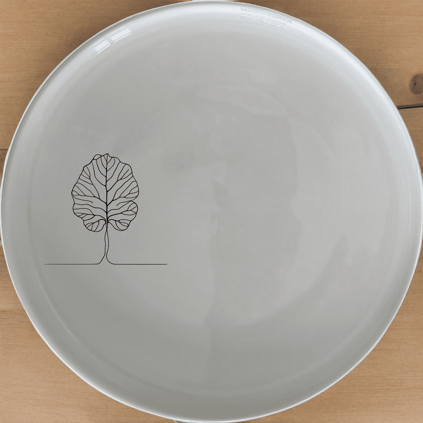 The Fiddle Leaf Dinner Plate Set of 4 features a minimalist design with a subtle leaf motif, perfect for modern dining.