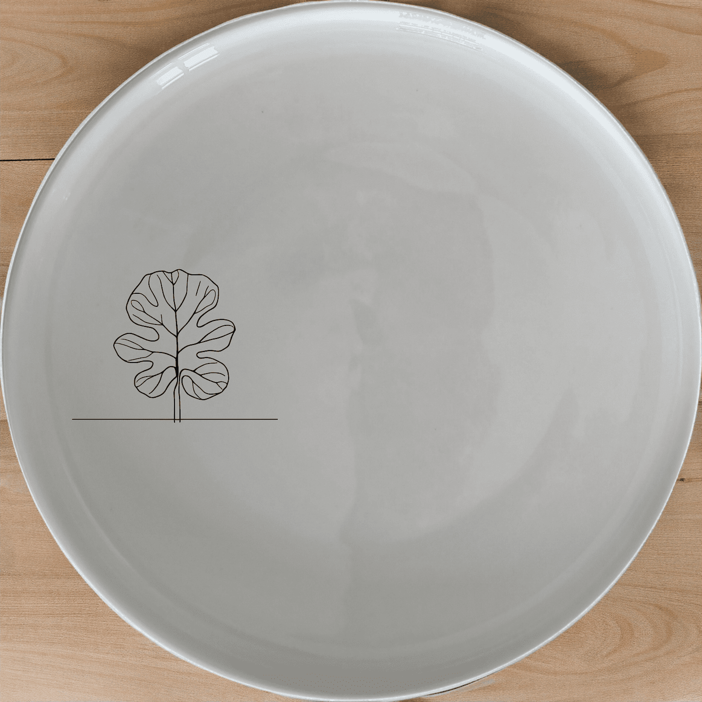 The Fiddle Leaf Dinner Plate Set of 4 features a minimalist design with a subtle leaf motif, perfect for modern dining settings.