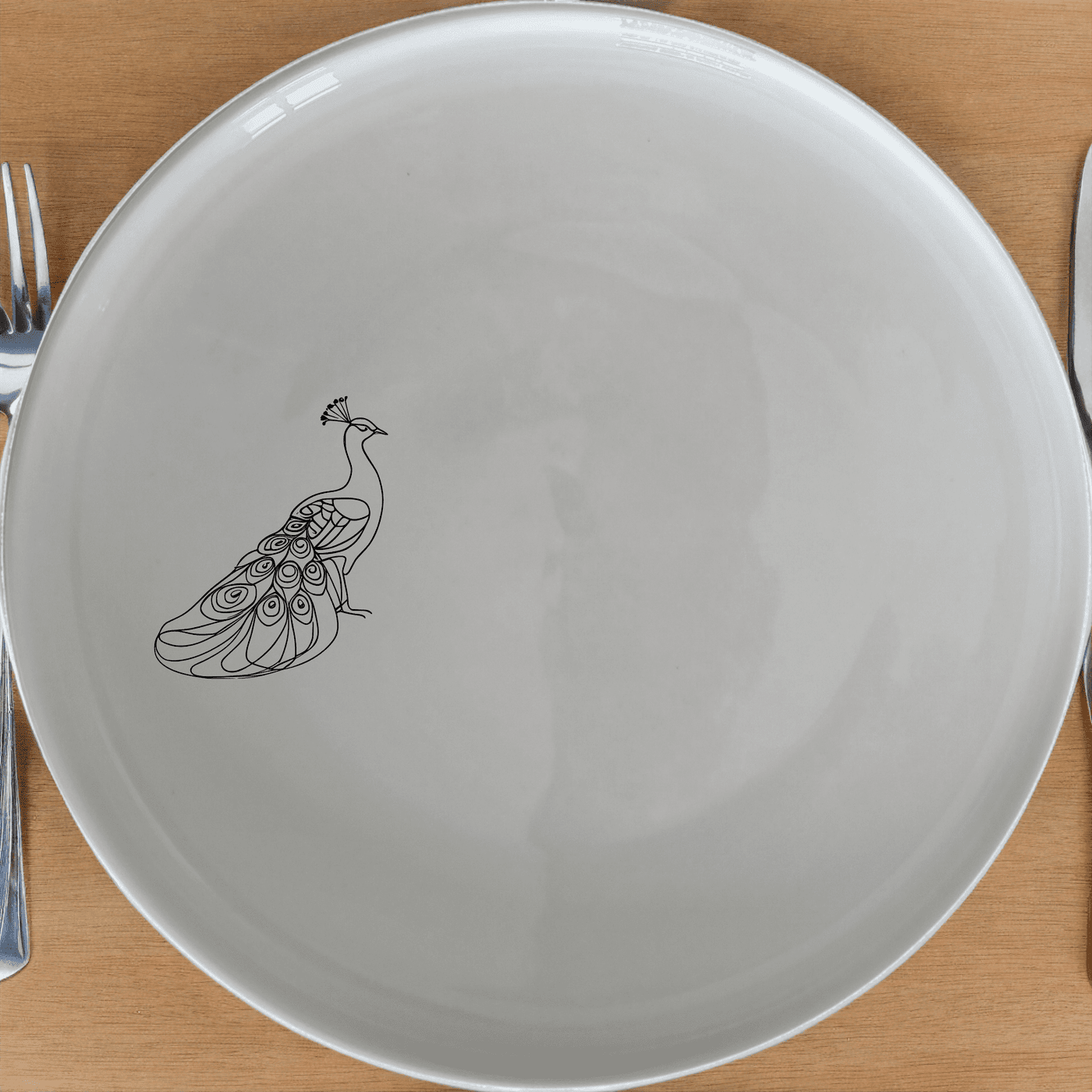 The Male Peacock Dinner Plate Set of 4 adds a touch of elegance to any dining table with its intricate design and classic white ceramic finish.
