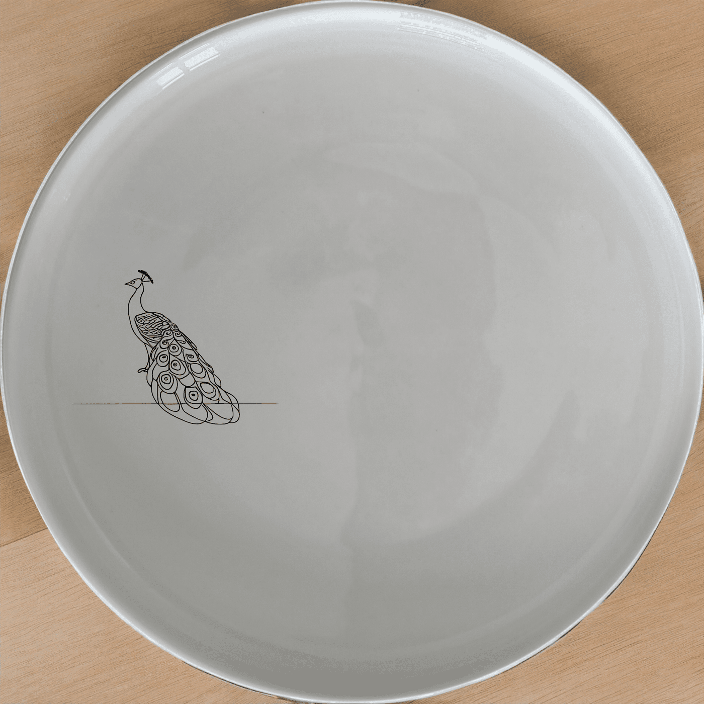 The Male Peacock Dinner Plate Set of 4 features a minimalist design with a subtle peacock silhouette, perfect for modern dining settings.