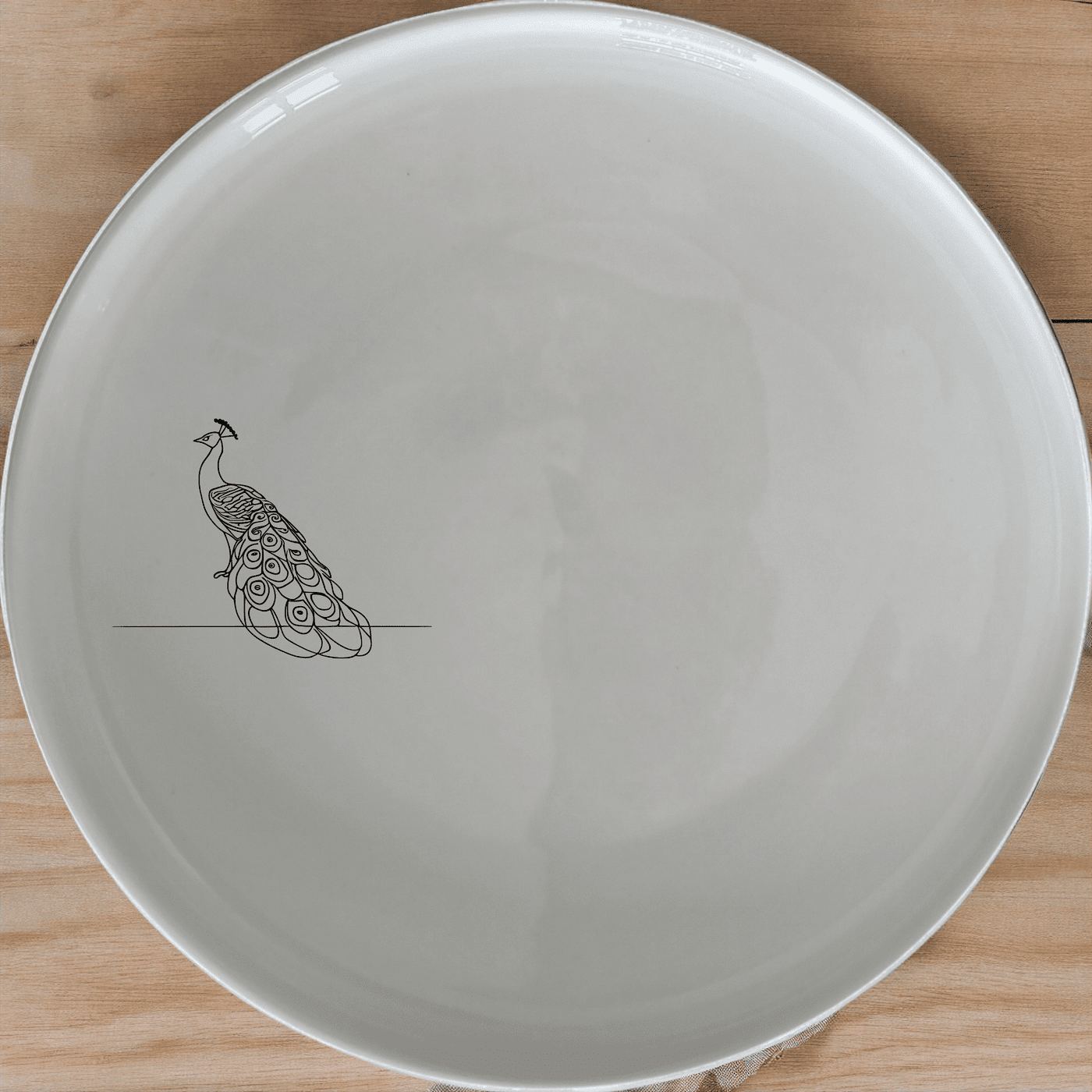 The Male Peacock Side Plate Set of 4 features a minimalist design with a subtle peacock silhouette, perfect for modern dining settings.
