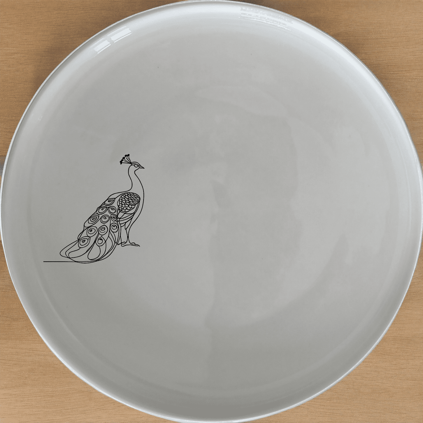 The Male Peacock Side Plate Set of 4 adds a touch of nature-inspired elegance to your dining table with its sleek design.