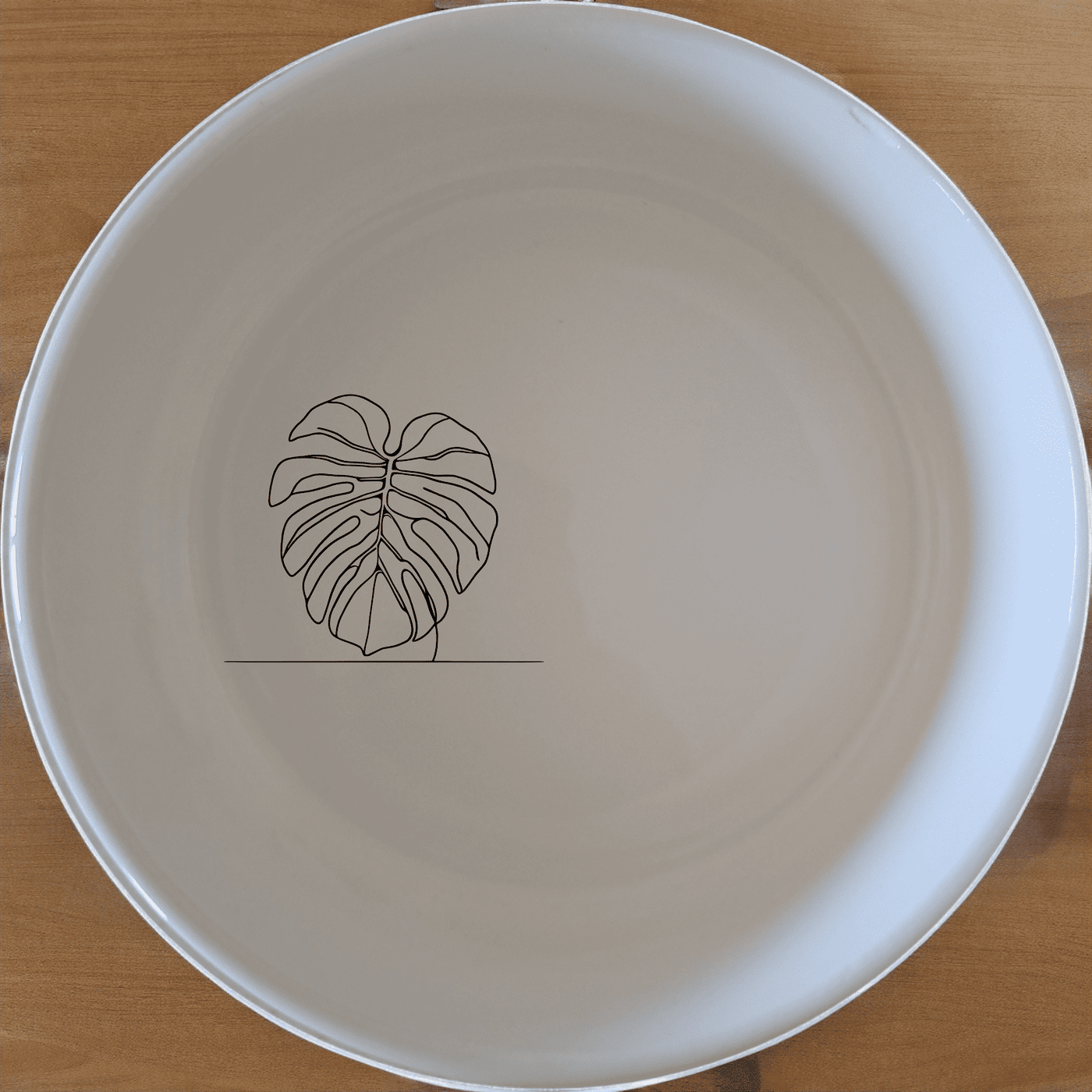 The Monstera Deliciosa Bowl Set of 4 features a modern, minimalist design with a subtle leaf motif, perfect for everyday use or special occasions.