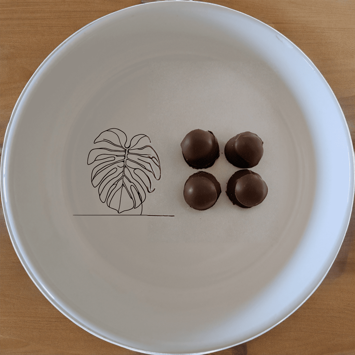 The Monstera Deliciosa Bowl Set of 4 features a modern, minimalist design with a subtle leaf motif, perfect for everyday use or special occasions.
