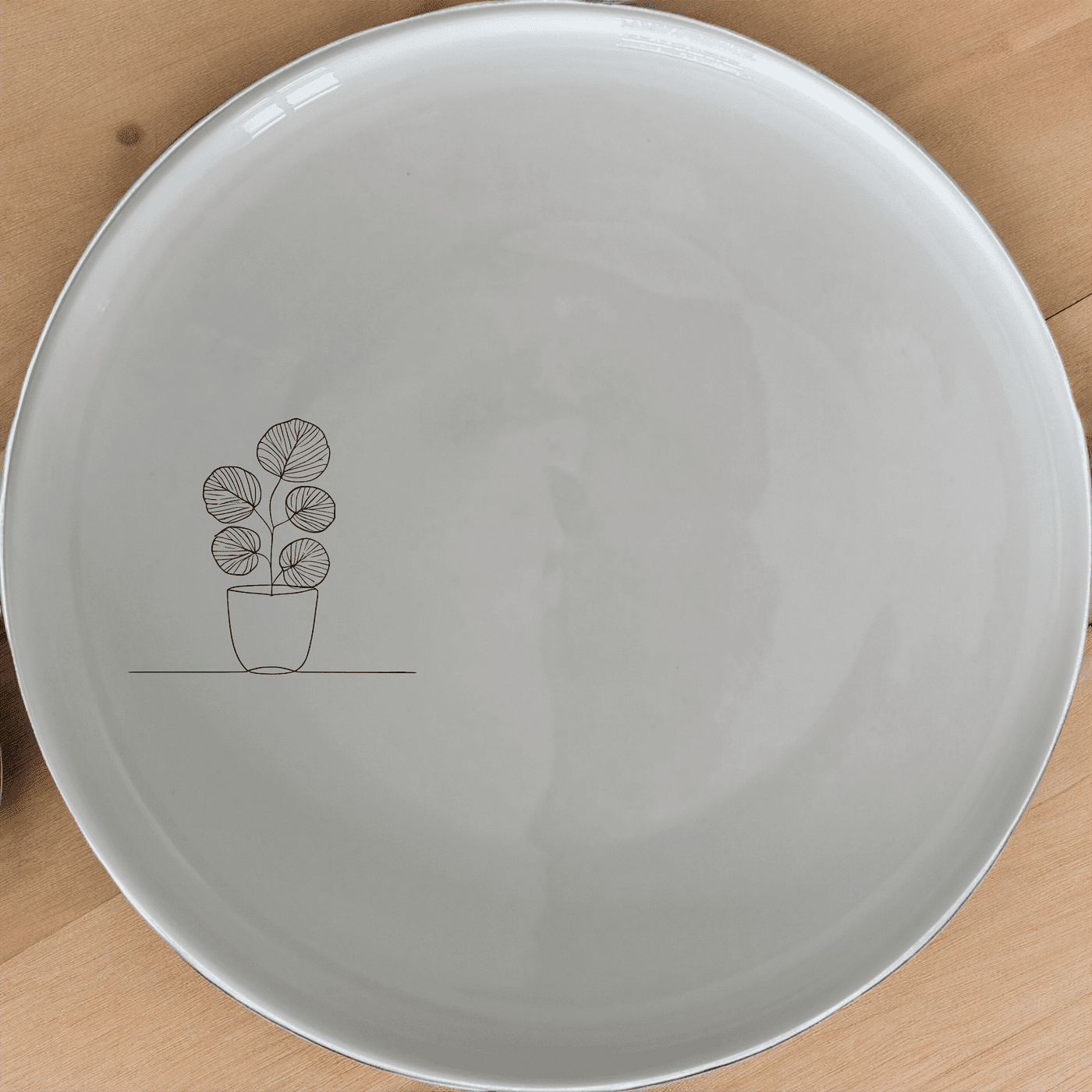 The Pilea Peperomioides Dinner Plate Set of 4 features a minimalist design perfect for modern dining. Crafted from durable ceramic, these plates are both dishwasher and microwave safe, making cleanup a breeze.