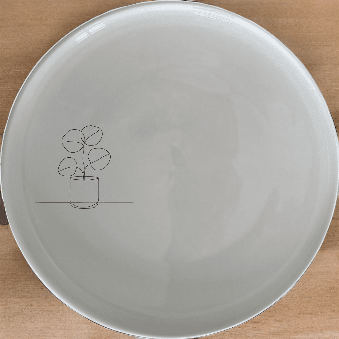 The Pilea Plant Dinner Plate Set of 4 features a minimalist design with a delicate plant illustration, perfect for modern dining settings.