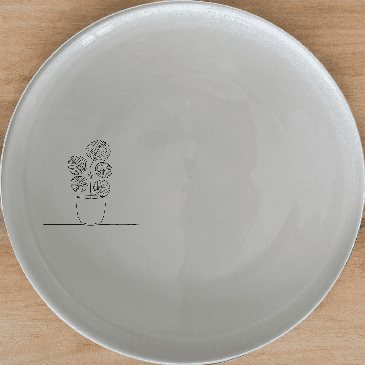 The Pilea Peperomioides Side Plate Set of 4 adds a touch of modern elegance to your dining table with its sleek design and minimalist aesthetic.