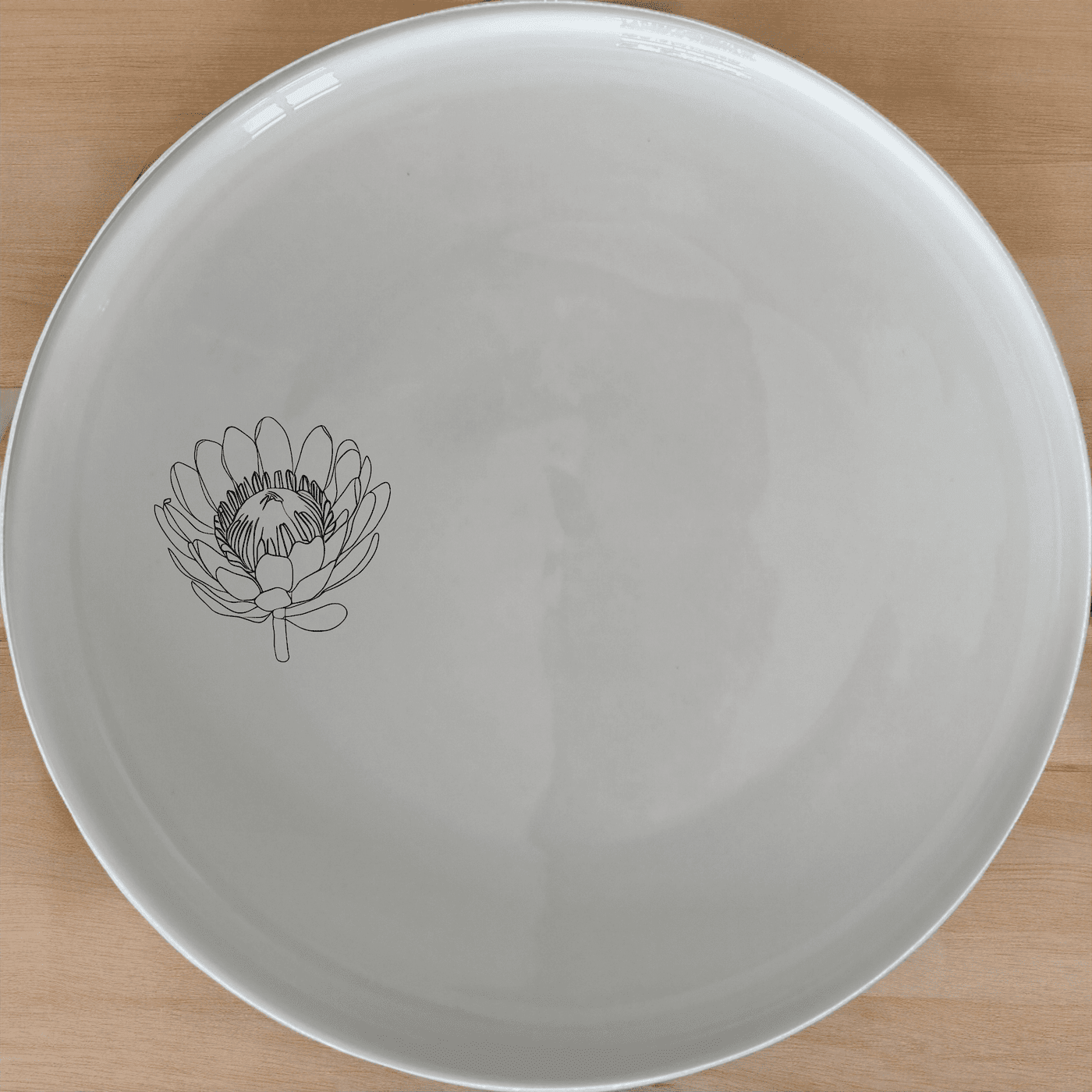 The Pincushion Protea Flower Side Plate Set of 4 features a delicate laser-etched design, perfect for everyday use or special occasions.