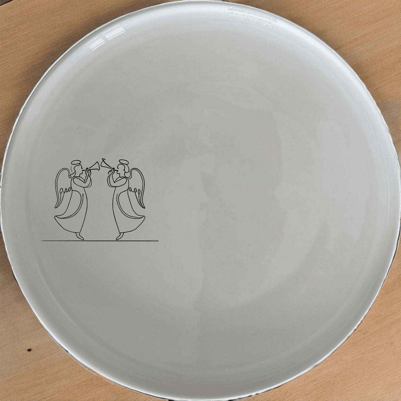 Angels Trumpet Dinner Plate Set of 4 - Range 4 is a stunning set of four white ceramic plates, each featuring an elegant laser-etched design of two angels playing trumpets. Perfect for elevating any dining experience.