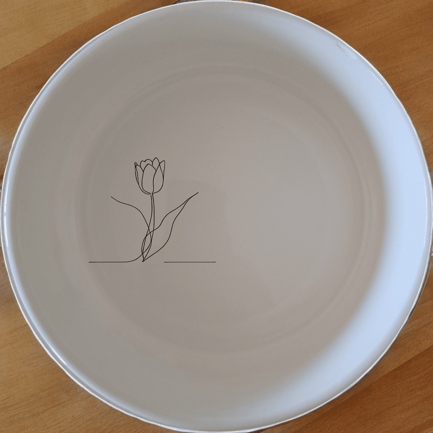The Tulips Bowl Set of 4 features a minimalist design with a subtle tulip illustration, perfect for everyday use and special occasions.