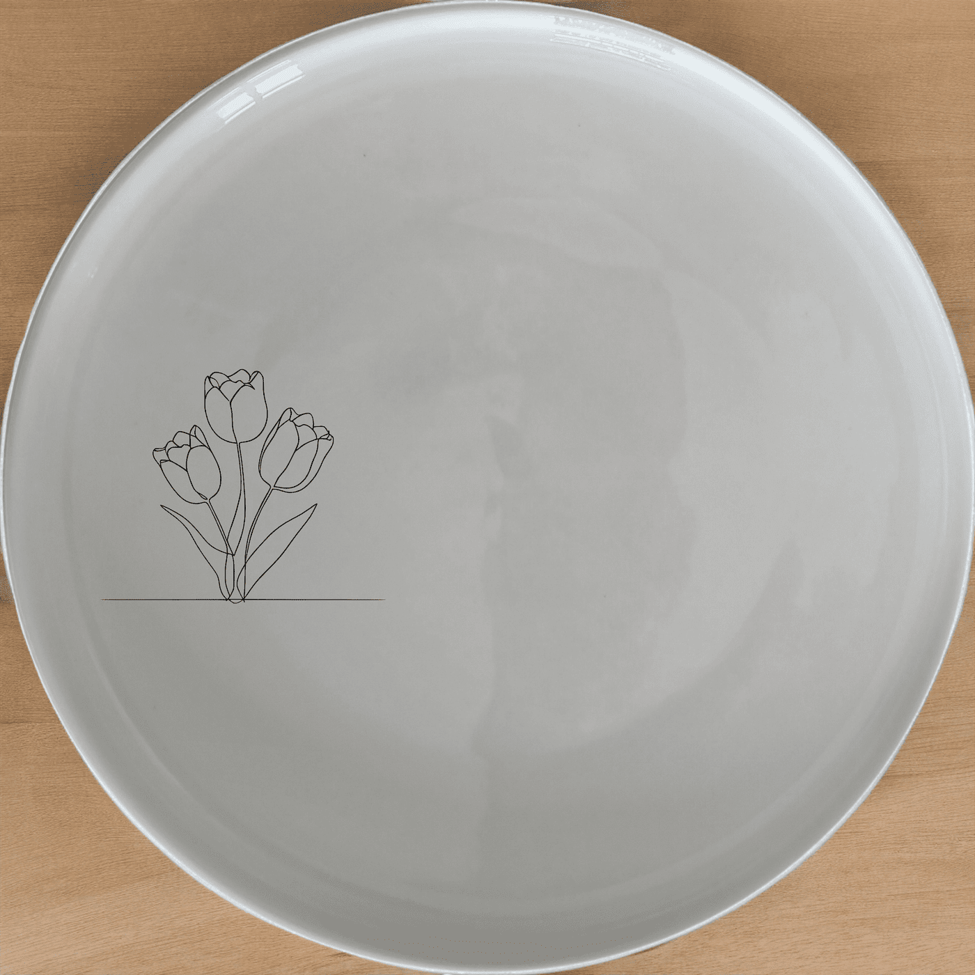 The Tulips Side Plate Set of 4 features a delicate laser-etched tulip design on white ceramic plates, perfect for everyday dining or special occasions.