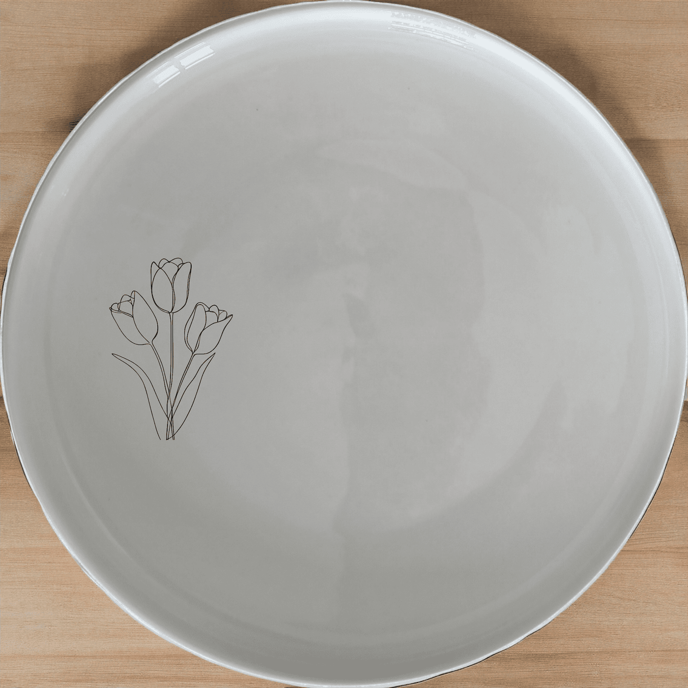 The Tulips Side Plate Set of 4 features a delicate laser-etched design on white ceramic, perfect for everyday use or special occasions.