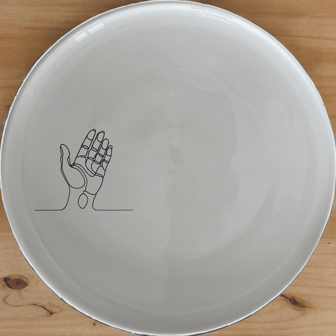 The Drawing Hand Dinner Plate Set of 4 - Range 3 features a minimalist design with an abstract hand illustration, perfect for modern dining.