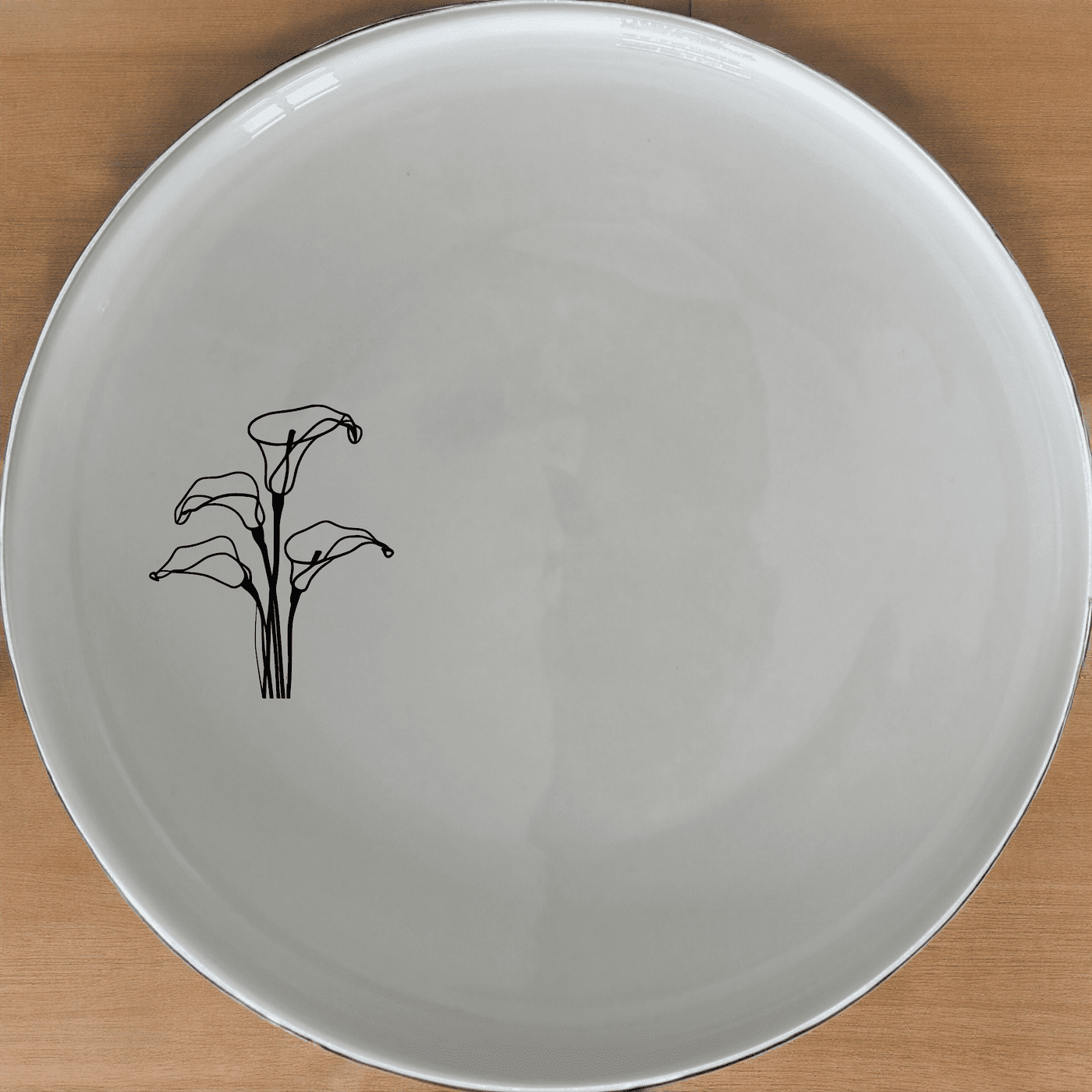 Arum Lilies Side Plate Set of 4 - Range 2 is a beautiful and elegant set of four white ceramic side plates, each featuring a delicate laser-etched arum lily design. Perfect for everyday use or special occasions, these plates are both dishwasher and microwave safe.