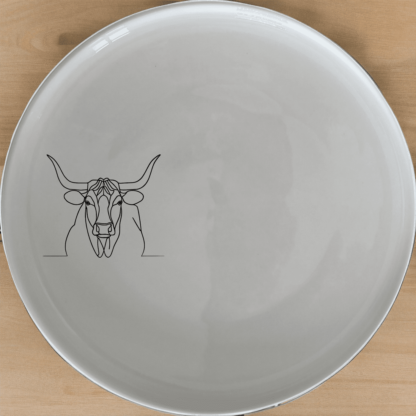 The Long Horn Steer Dinner Plate Set of 4 - Range 2 features a sleek, minimalist design perfect for modern dining. Each plate showcases an elegant longhorn steer silhouette, adding a touch of rustic charm to your table setting.