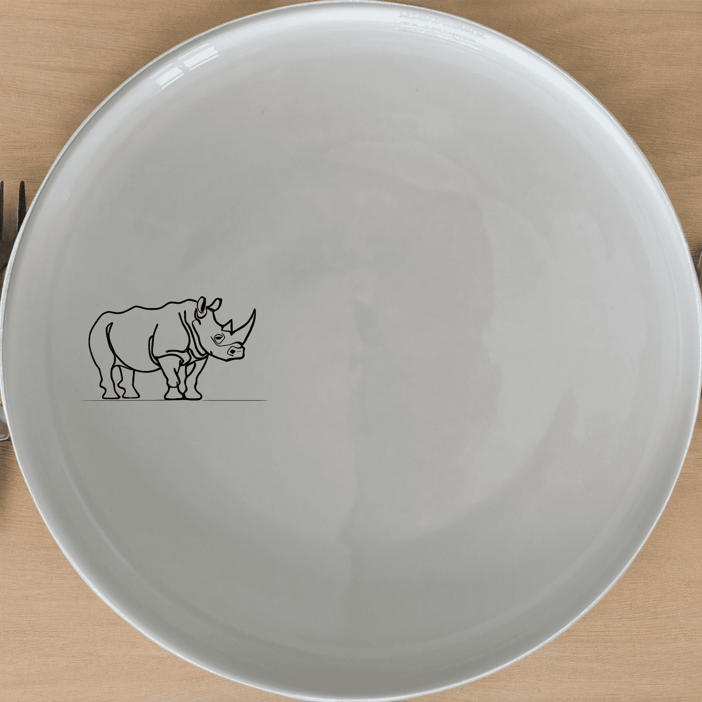 The Silhouette Rhino Dinner Plate Set of 4 features a striking black silhouette of an African rhino on a white ceramic plate, perfect for adding a touch of wildlife elegance to your dining table.
