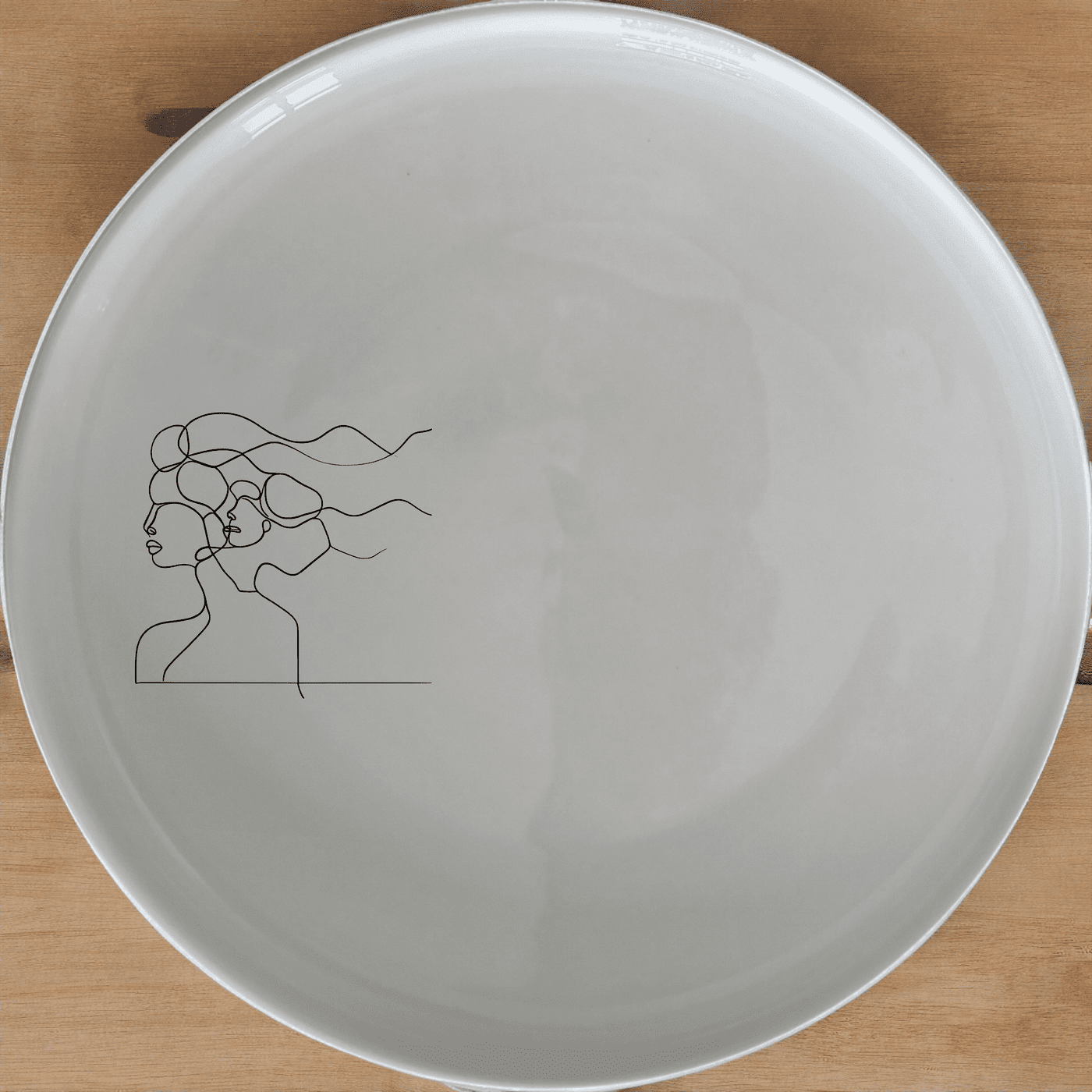 The Woman Faces Hair Side Plate Set of 4 features a minimalist design with abstract faces in hair, perfect for modern dining.