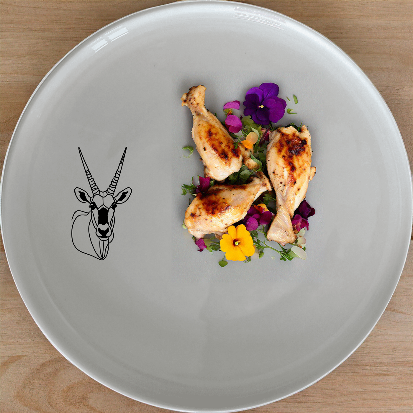 The Gemsbok Bust Dinnerware Set of 12 - Range 1 features elegant ceramic plates with a striking gemsbok design, perfect for modern dining.