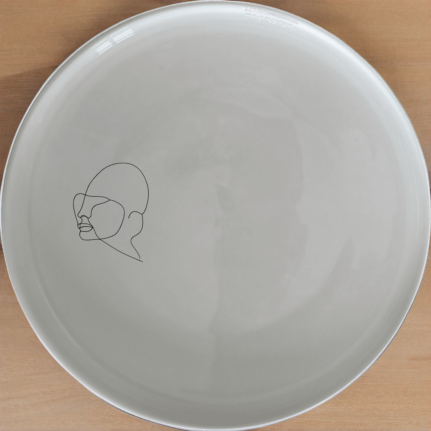 This Line Art Faces Dinner Plate Set of 4 features minimalist line art designs, perfect for modern dining settings. Each plate showcases a unique face silhouette, adding a contemporary touch to your table. Crafted from durable ceramic, these plates are microwave and dishwasher safe, making them ideal for everyday use.